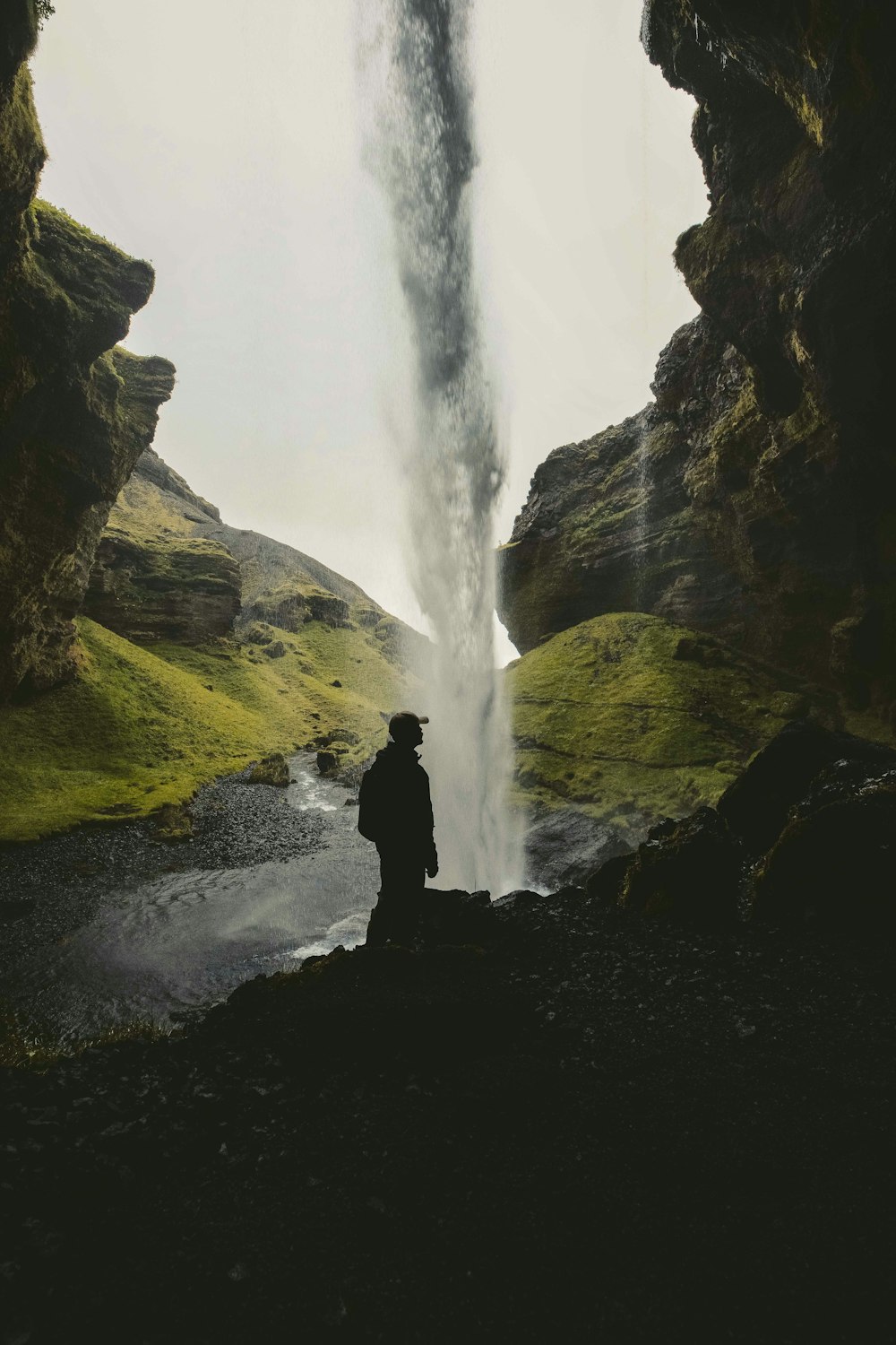 Un homme debout devant une cascade