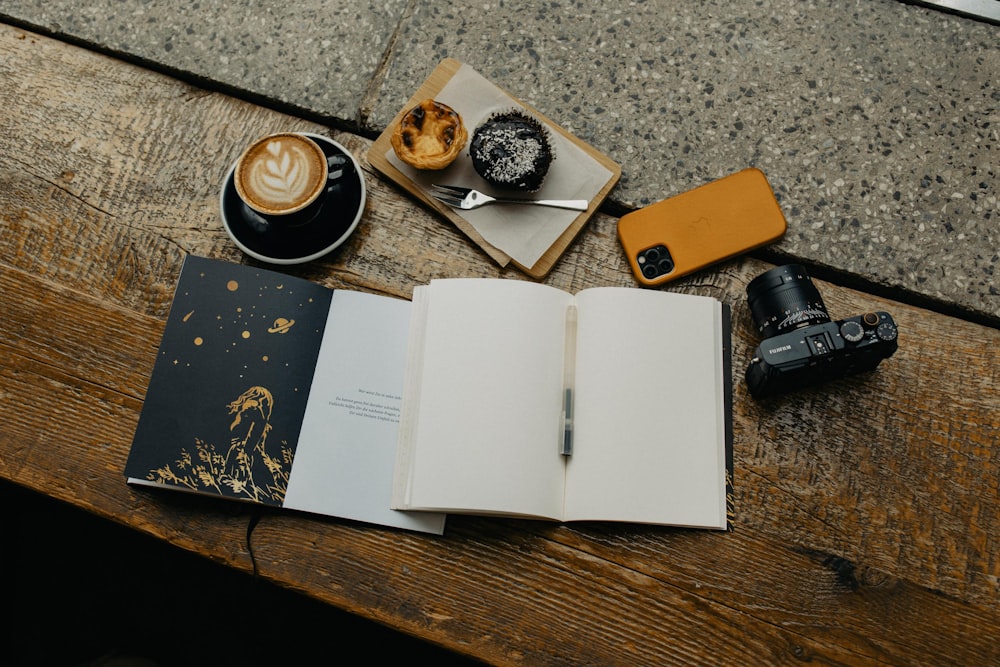 커피 한 잔 옆에 있는 나무 테이블 위에 앉아 펼쳐진 책