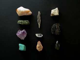 Cornerstone gemstones from a private Bangkok inventory, showing mixed rough and cut stones on a wooden table.
