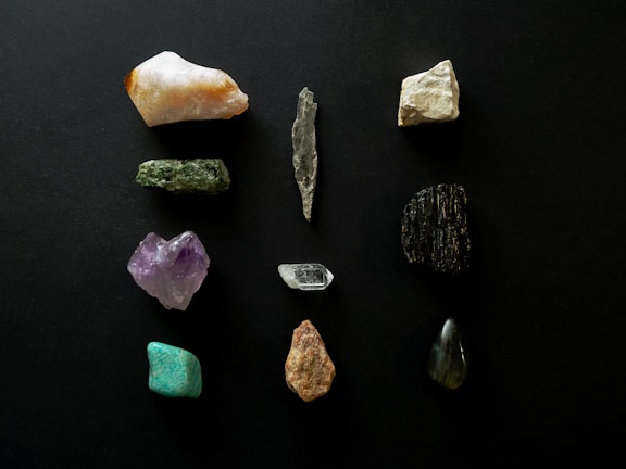 A collection of assorted gemstones and minerals displayed neatly on a wooden table.