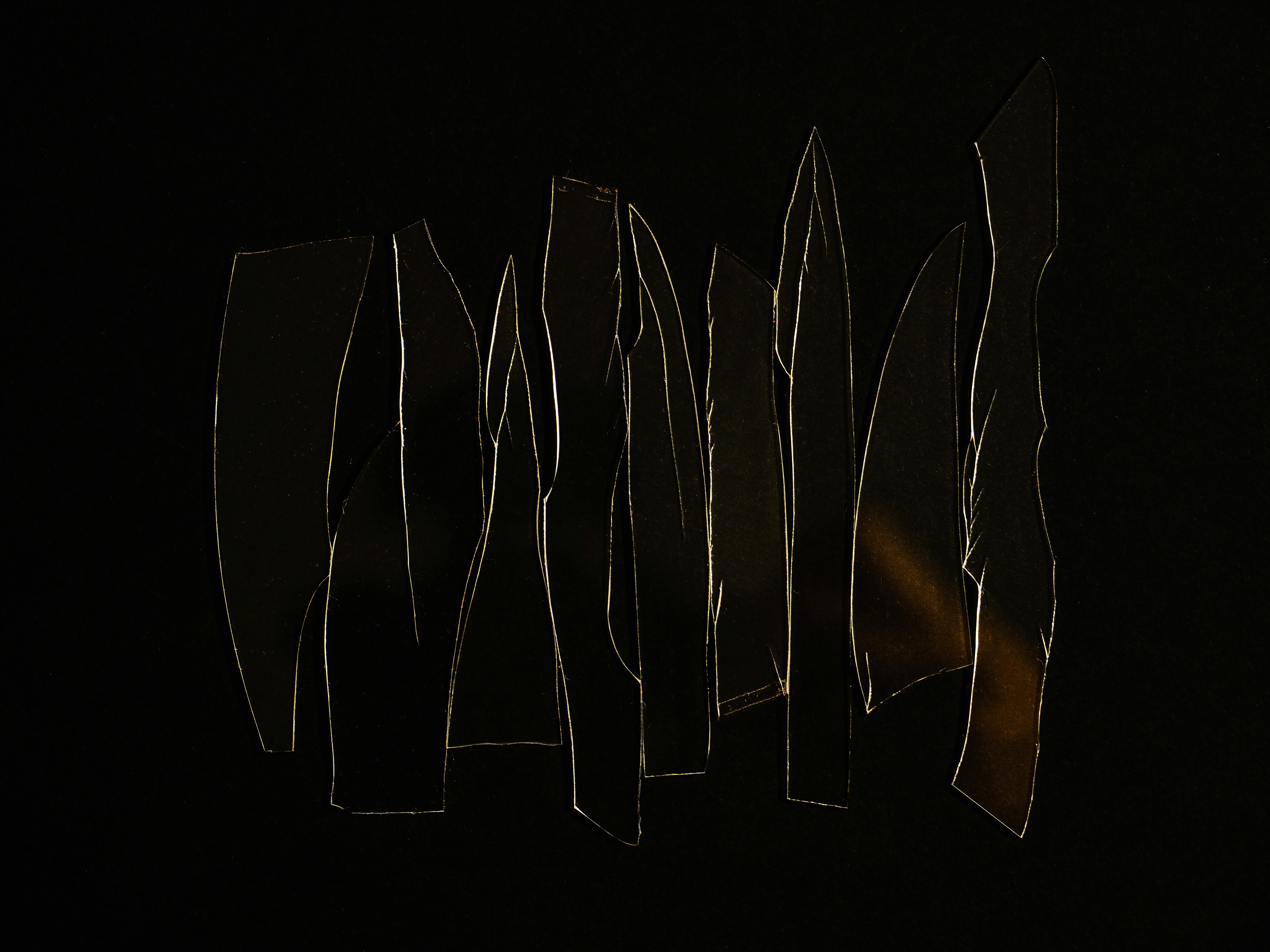 a group of cut up pieces of paper in the dark