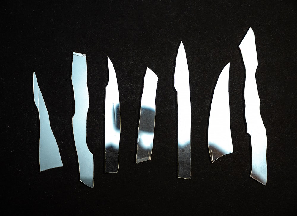 a group of knives cut in half on a black surface