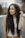 a woman with long curly hair standing in the street