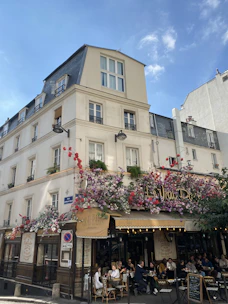 A charming Parisian café terrace with people enjoying coffee on a sunny afternoon.