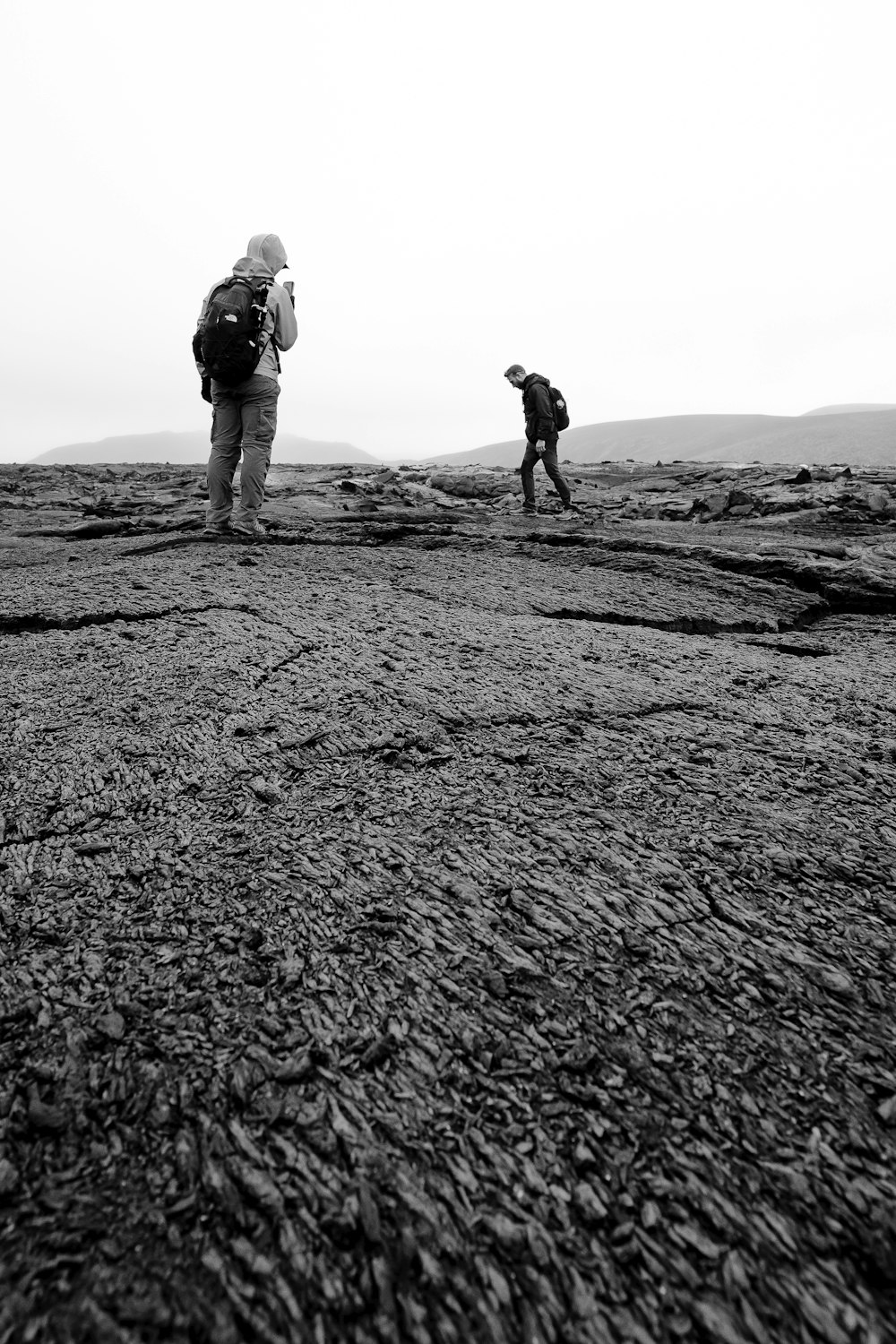 a couple of people standing on top of a dry grass field