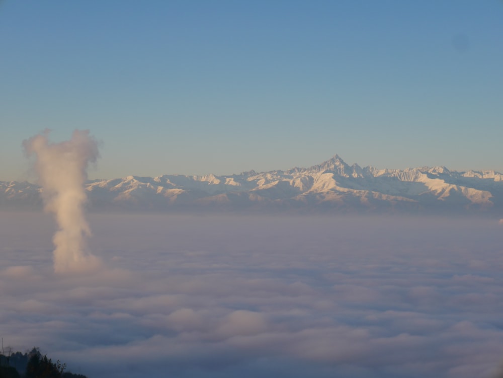 Una vista de una cadena montañosa con una nube en primer plano