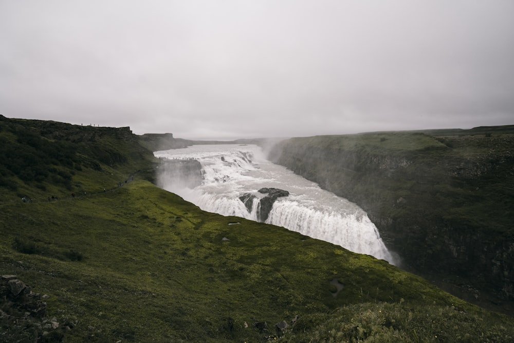 a view of a waterfall in the middle of a field