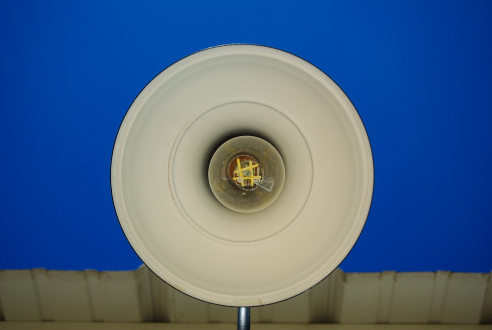 a close up of a white speaker with a blue background