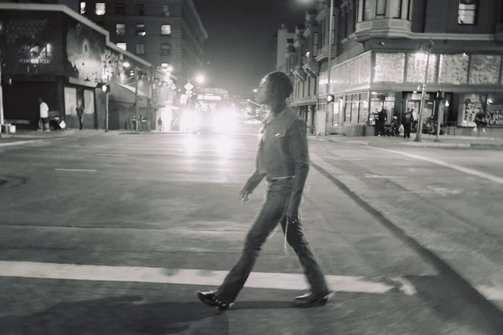 Une femme traversant une rue la nuit