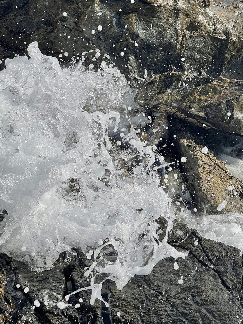 a close up of water splashing on rocks