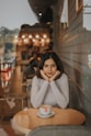 a woman sitting at a table with a cup of coffee