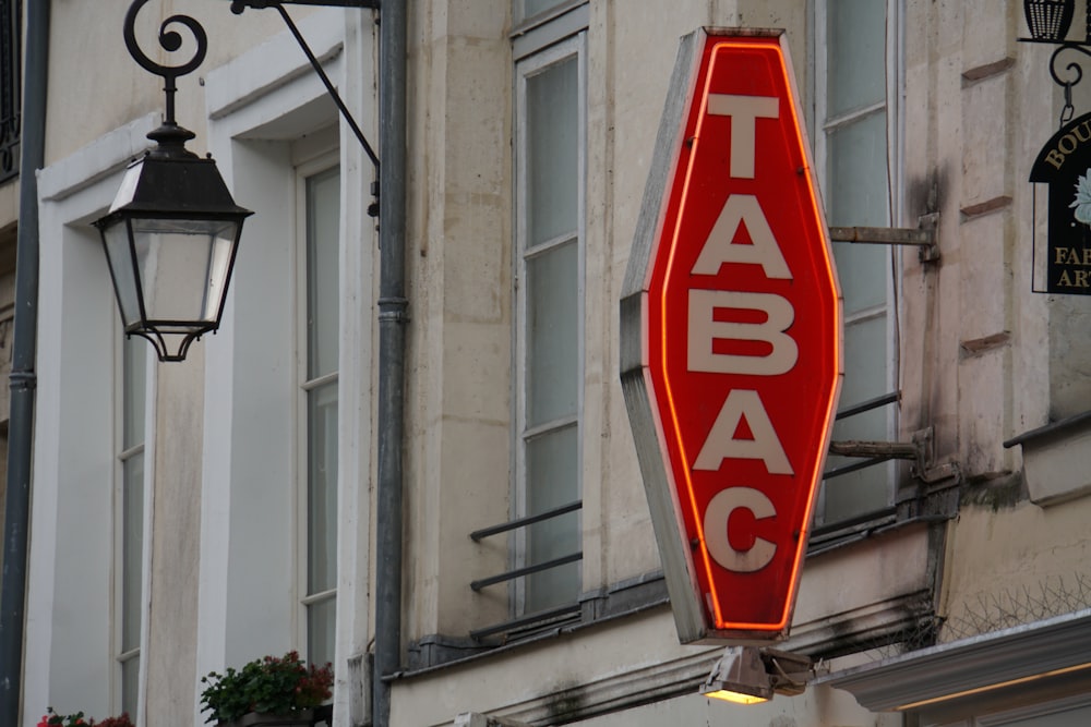 a red sign hanging from the side of a building