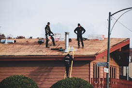 a couple of men standing on top of a roof