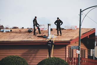 a couple of men standing on top of a roof