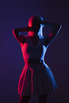 A silhouette of a poised woman in a sleek, high-fashion outfit against a dimly lit, cinematic backdrop.
