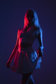 Arrangement of custom cheer uniforms laid out under dramatic lighting highlighting fabric shine.