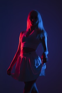 Arrangement of custom cheer uniforms laid out under dramatic lighting highlighting fabric shine.