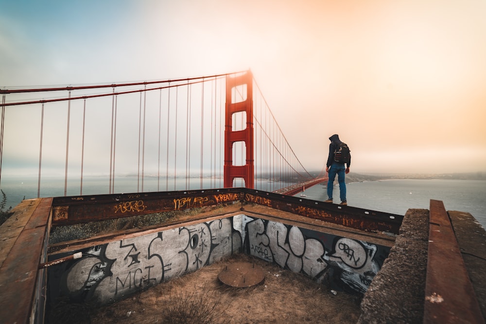 a man standing on the edge of a bridge