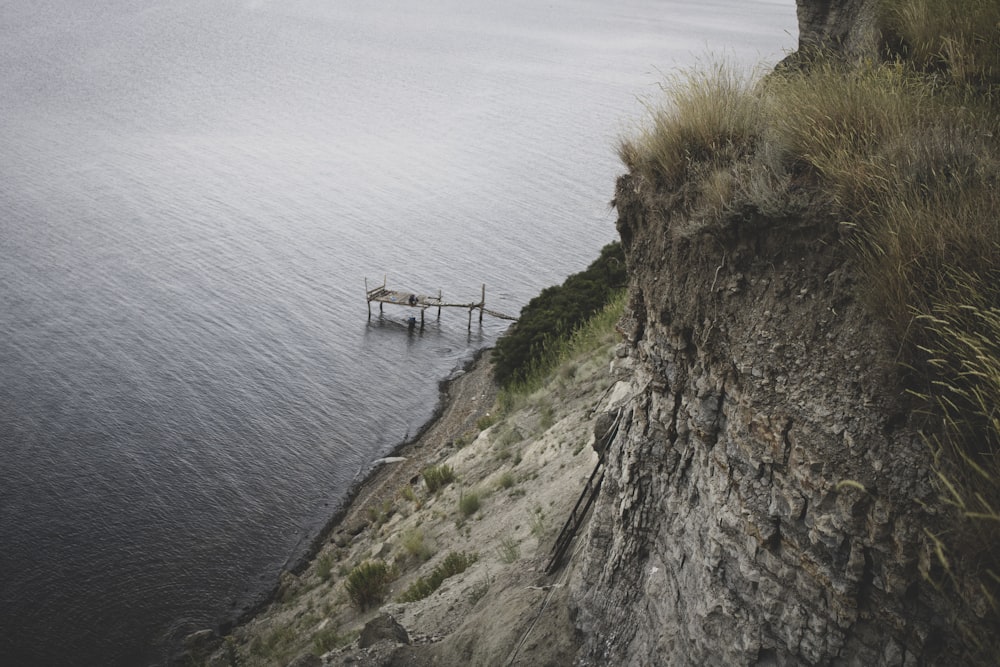 a pier on the edge of a cliff overlooking a body of water