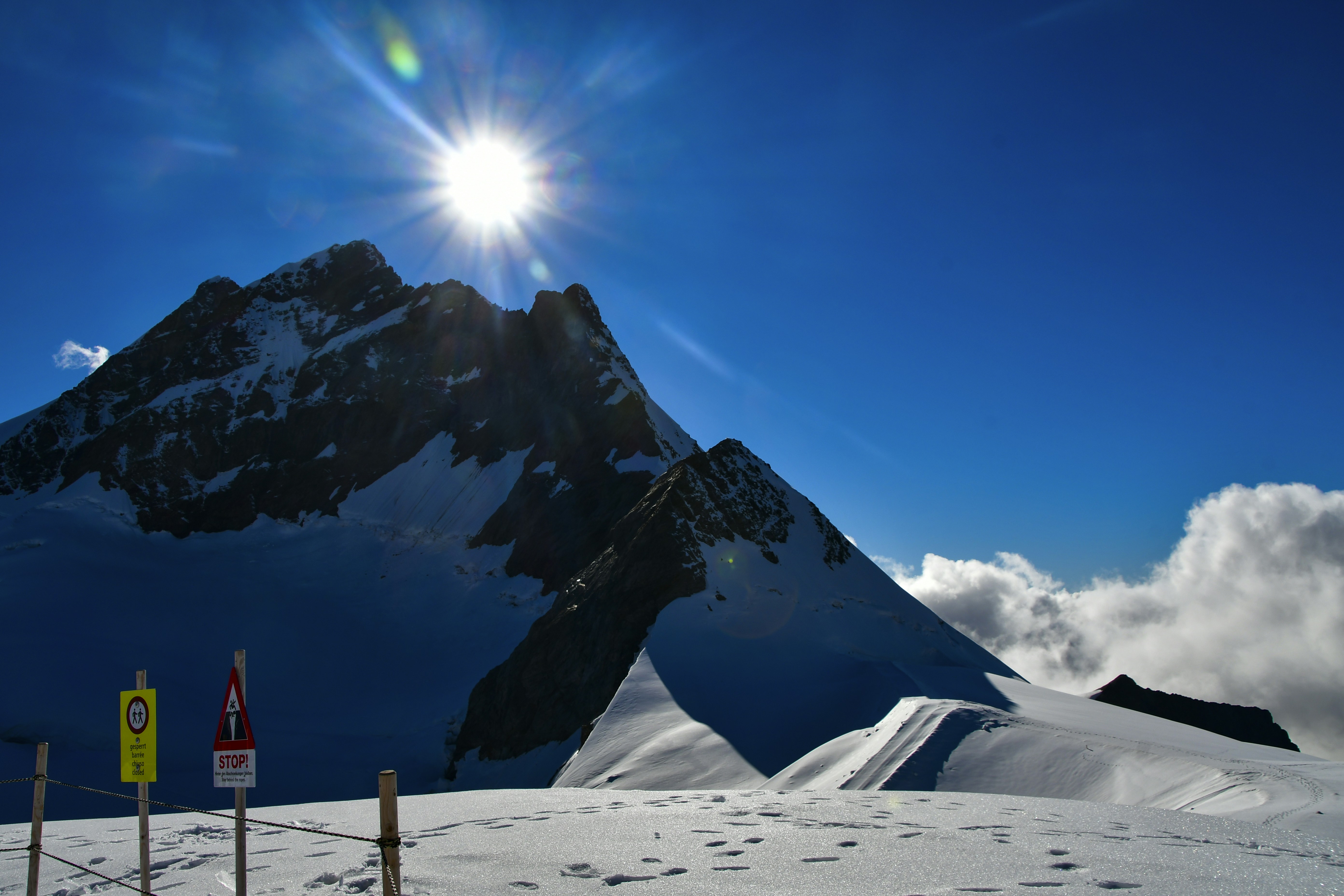 the sun shines brightly over a snowy mountain