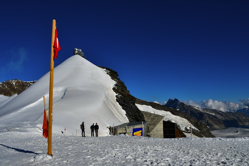 a group of people standing on top of a snow covered slope