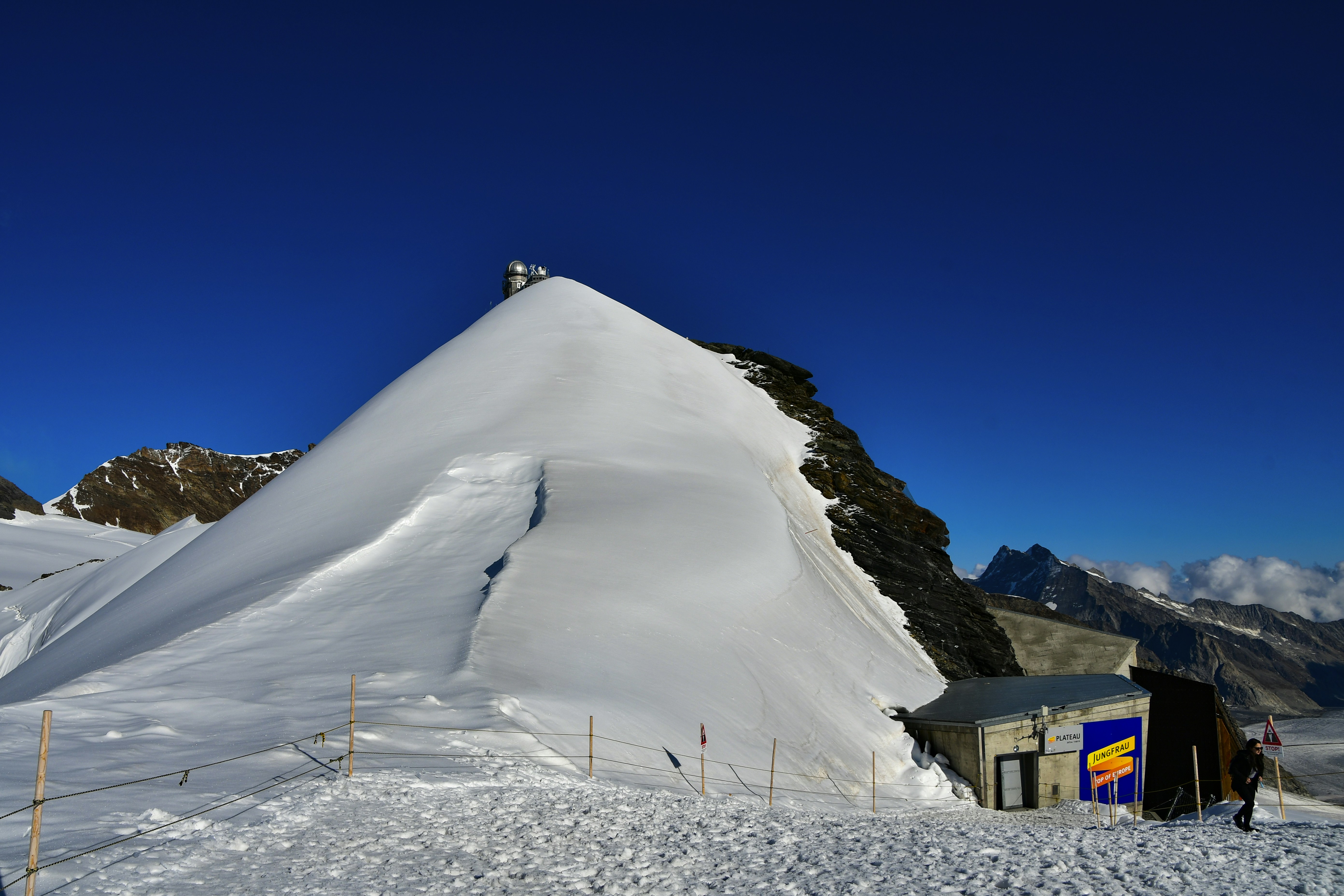 a snow covered mountain with a small building