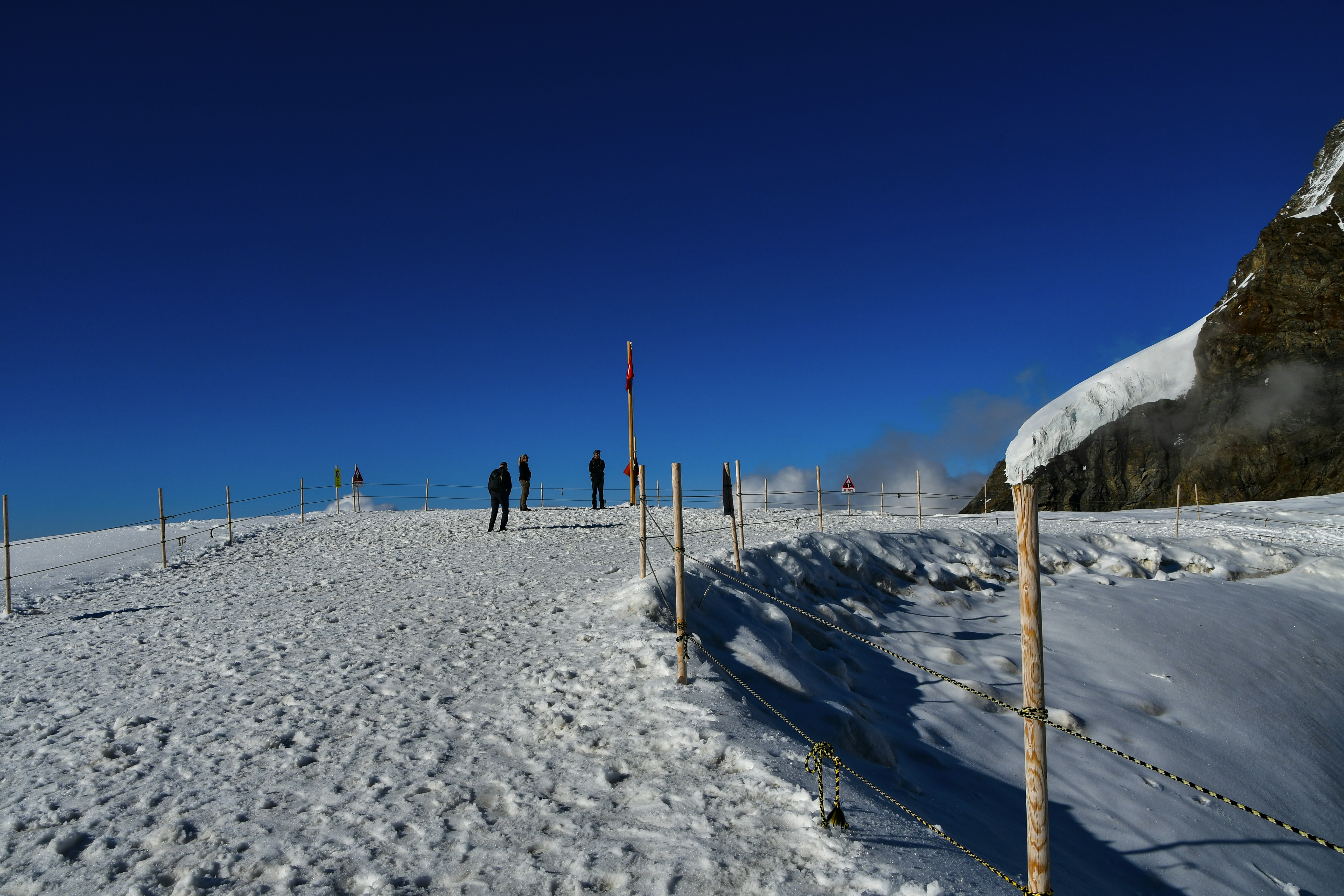 a group of people standing on top of a snow covered slope