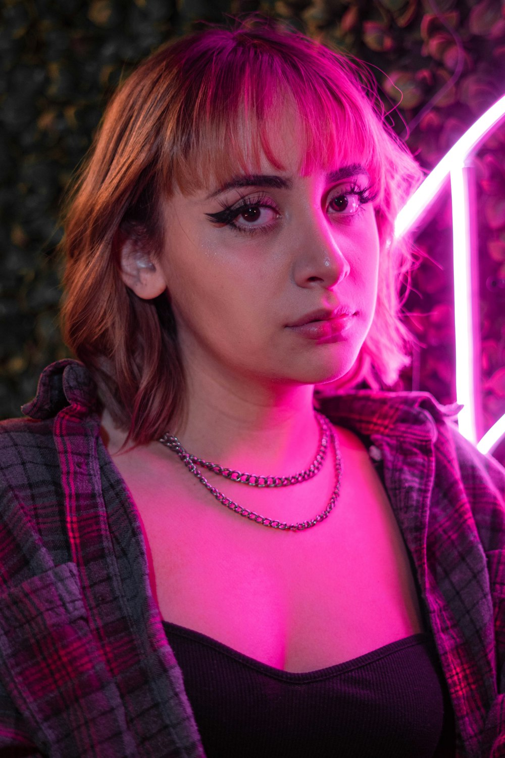 a woman in a black top and a pink light