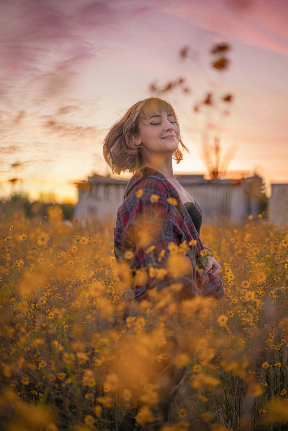 uma mulher de pé em um campo de flores amarelas