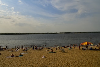 Vibrant beach towels spread out on warm sand under a sunny sky.