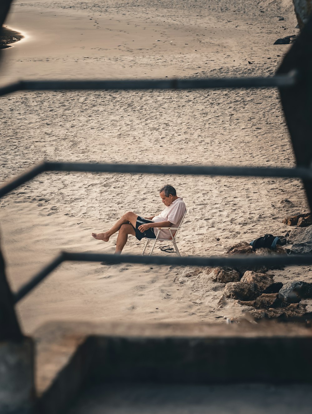 a man sitting in a chair on the beach