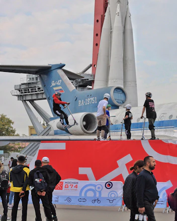 A diverse group of people gathered around a model rocket, planning a civilian space mission.