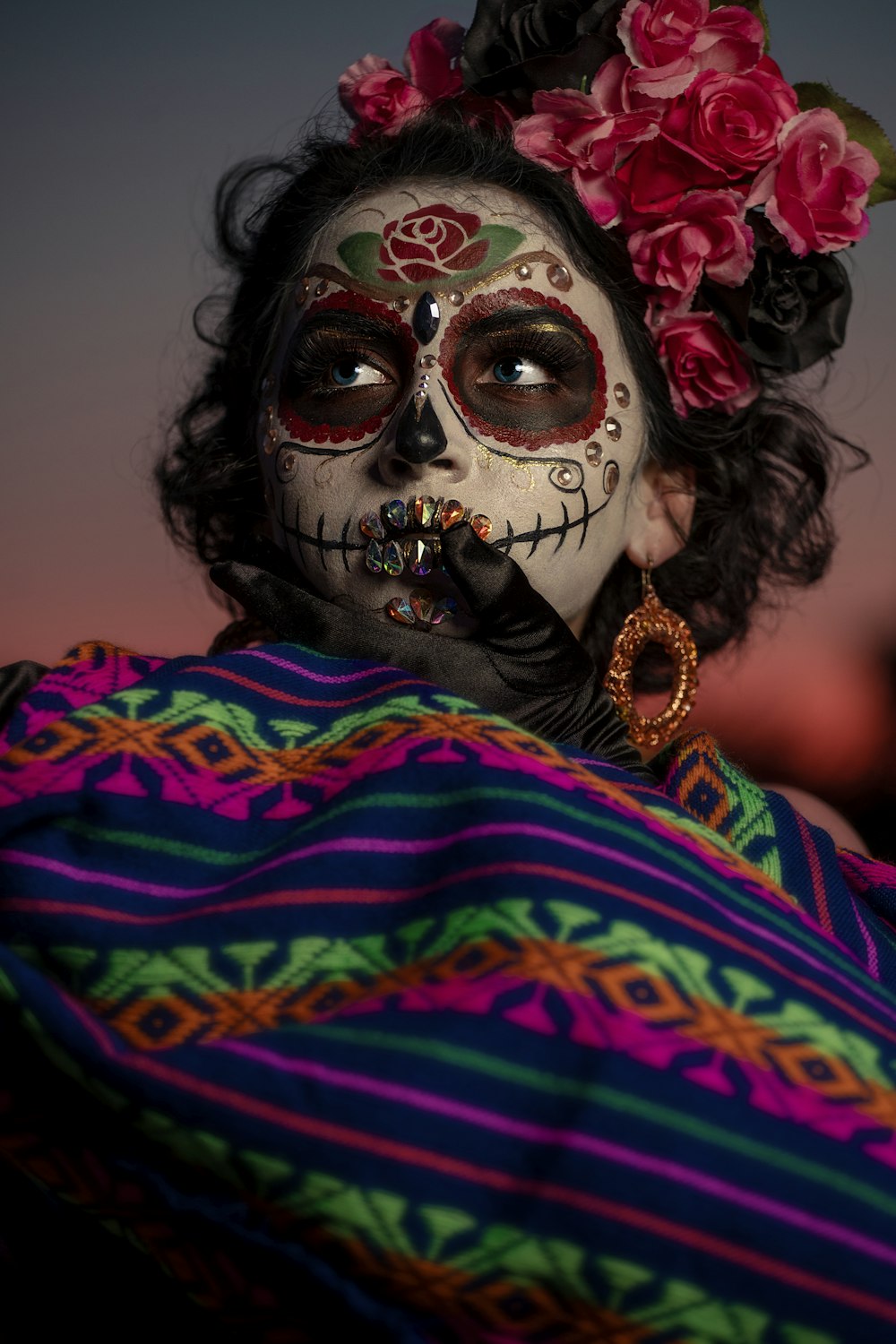 a woman with a skull make up and flowers in her hair