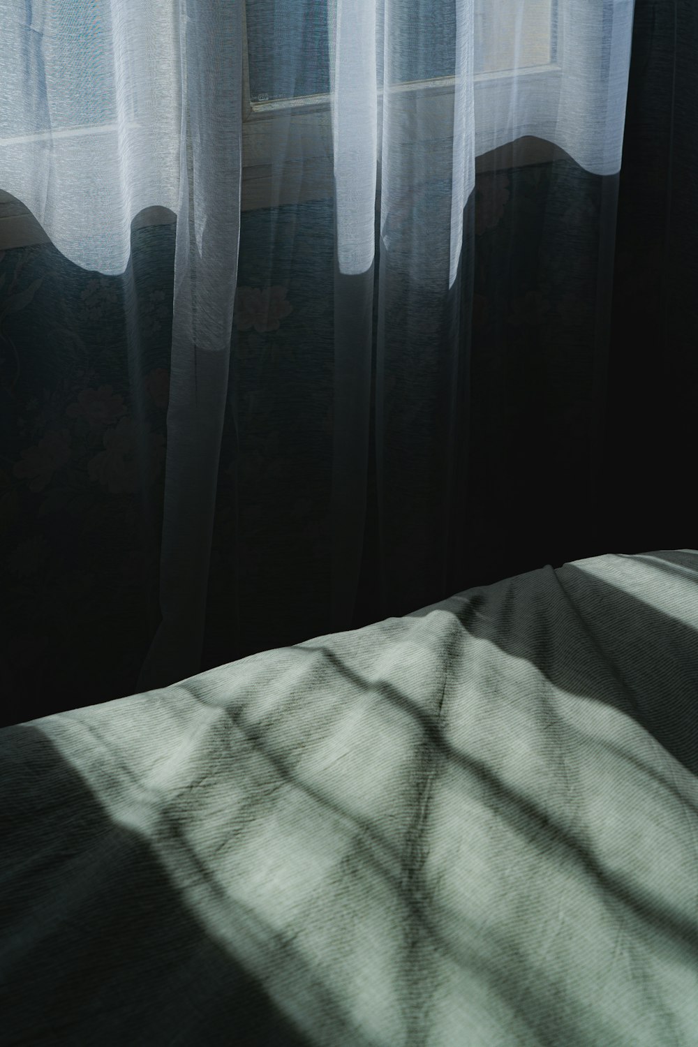 L'ombra di un letto davanti a una finestra