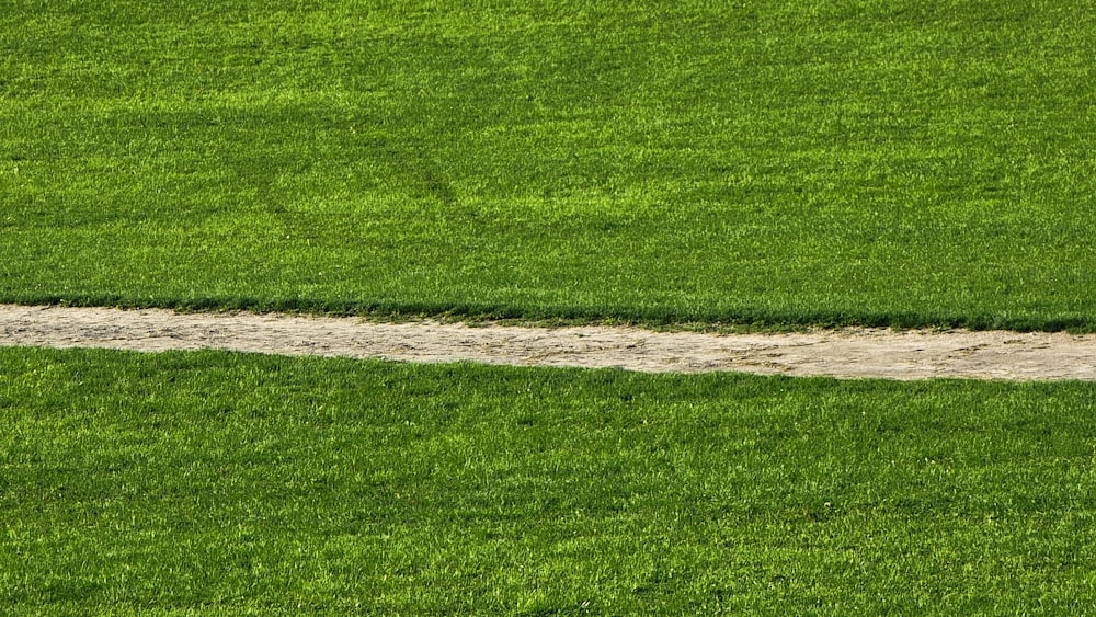 a baseball player walking across a lush green field