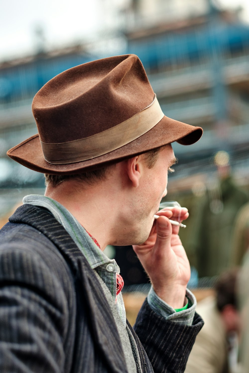 a man in a hat smoking a cigarette