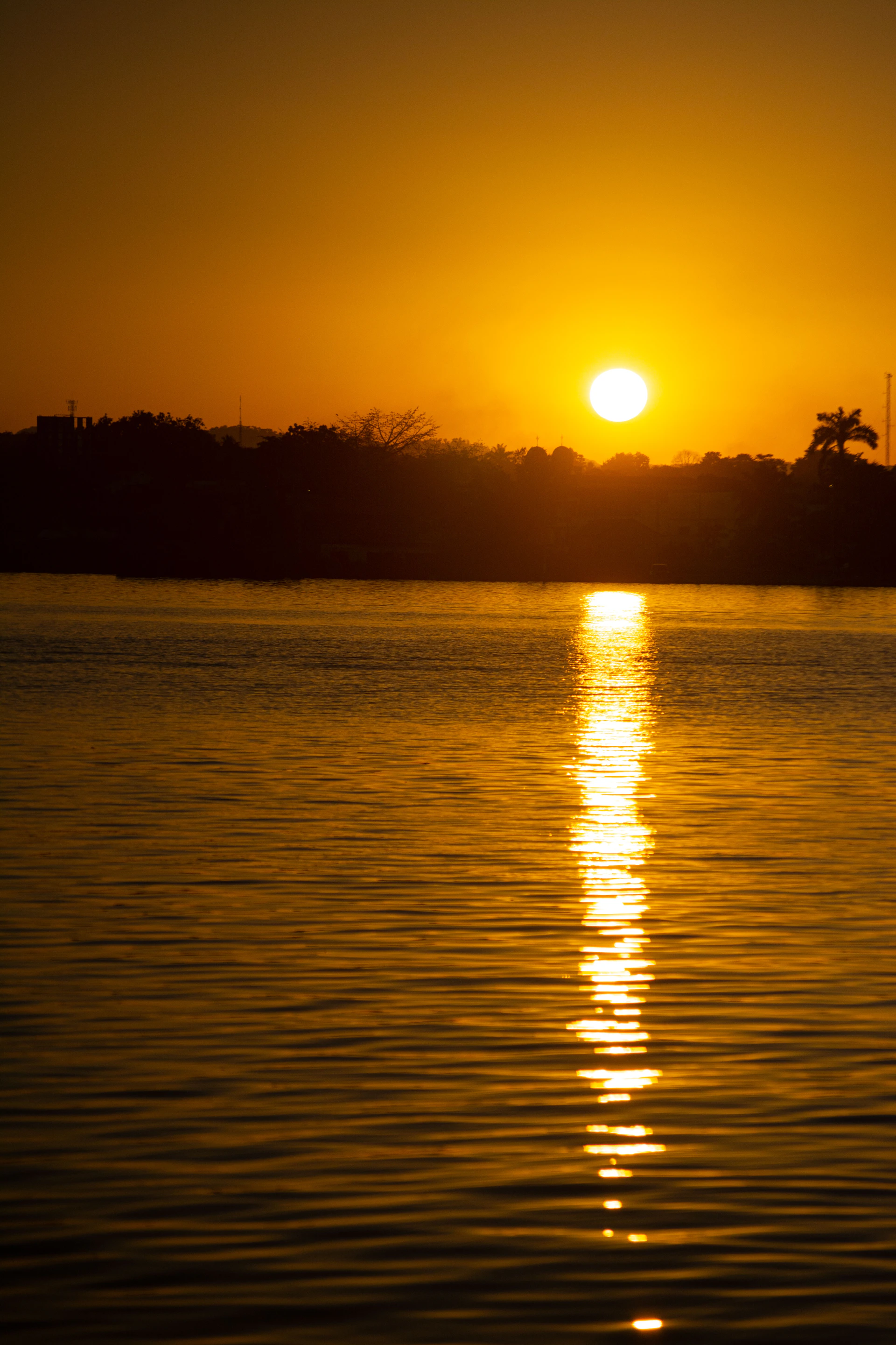 a large body of water with a sunset in the background