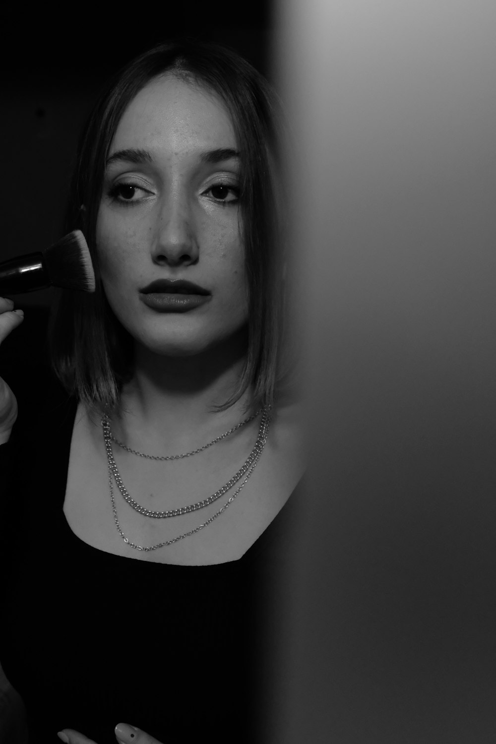 a woman in a black shirt is brushing her hair