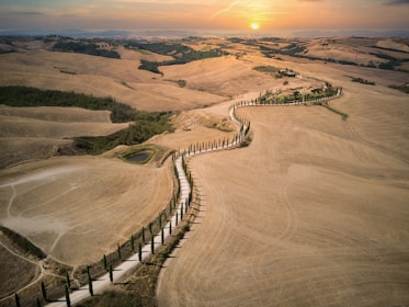 an aerial view of a field with a fence in the foreground