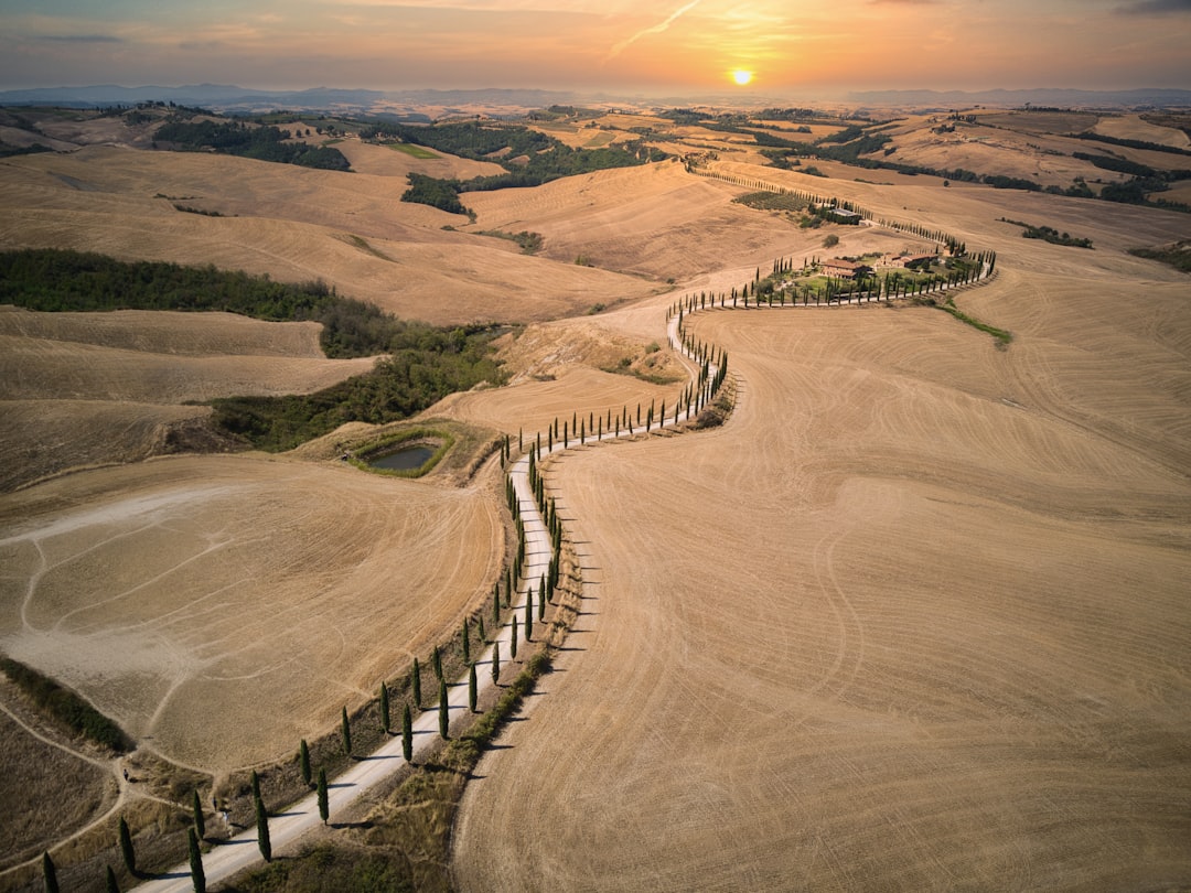 an aerial view of a field with a fence in the foreground, sundown of tuscany landscape - Italia