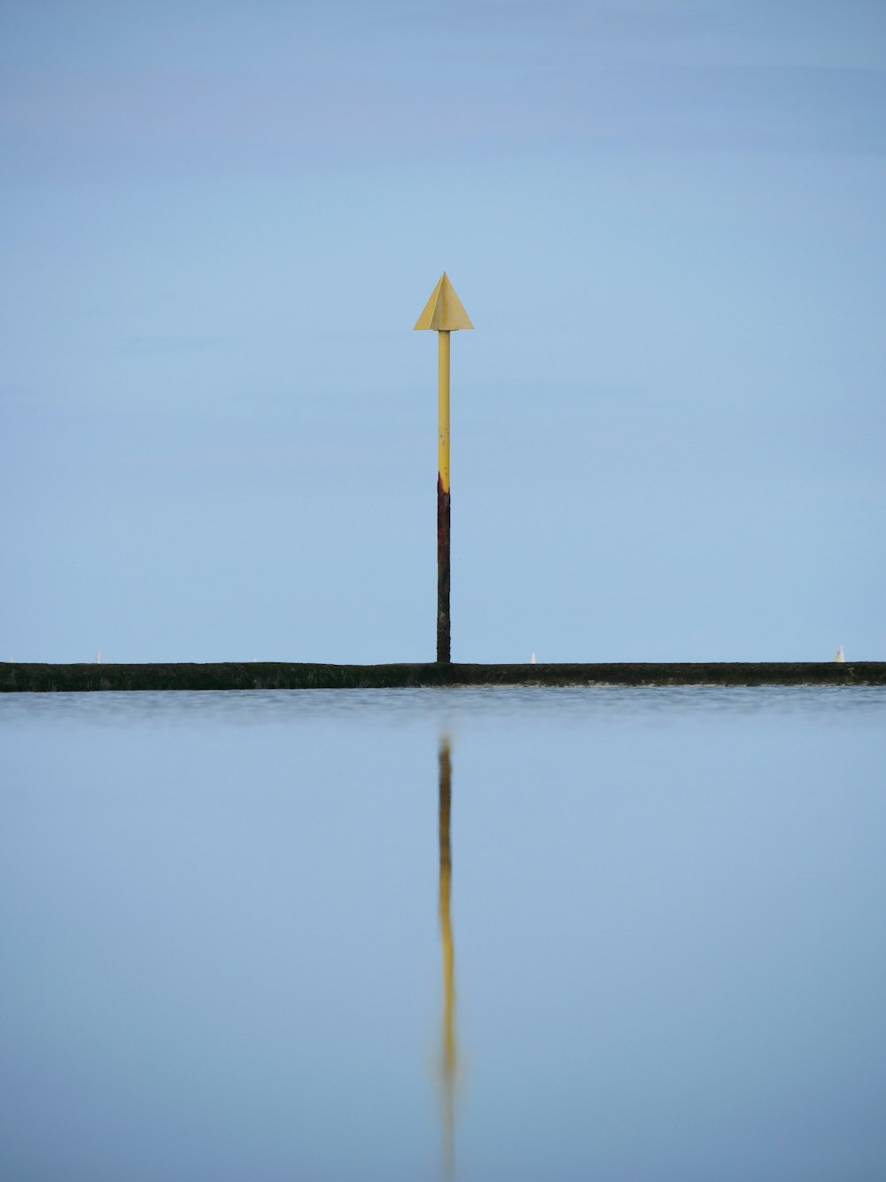 a pole in the middle of a body of water