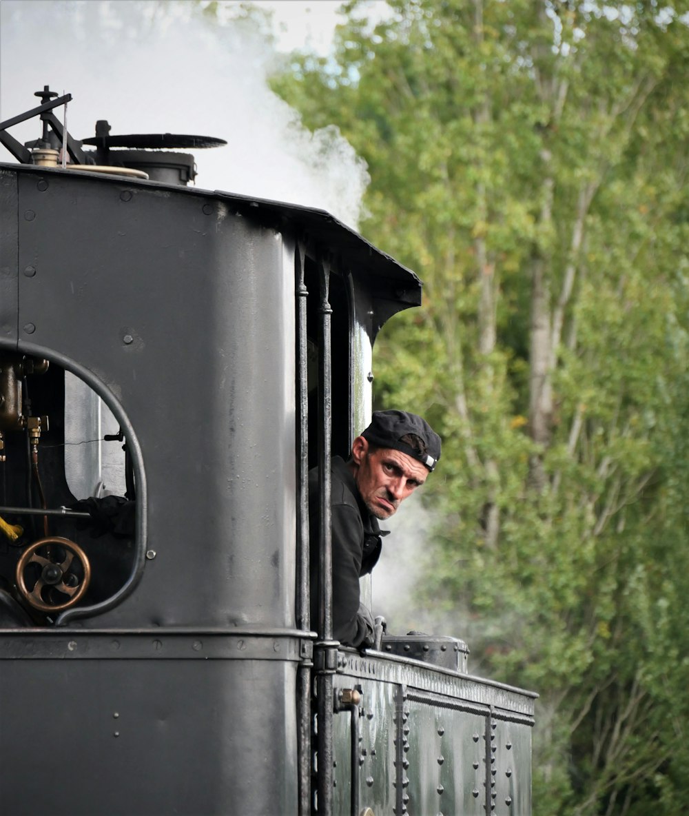 a man looks out the window of a train