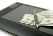 Stack of organized financial reports with a pen resting on top.