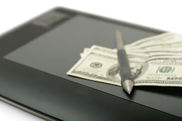 Stack of organized financial reports with a pen resting on top.