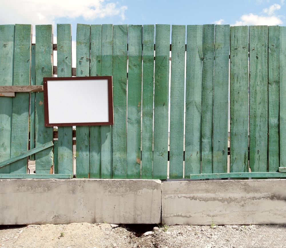 a wooden fence with a mirror hanging on it
