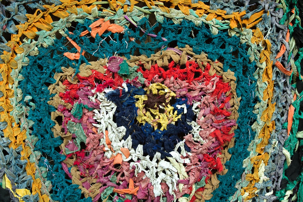 um doily de crochê multicolorido com um coração sobre ele