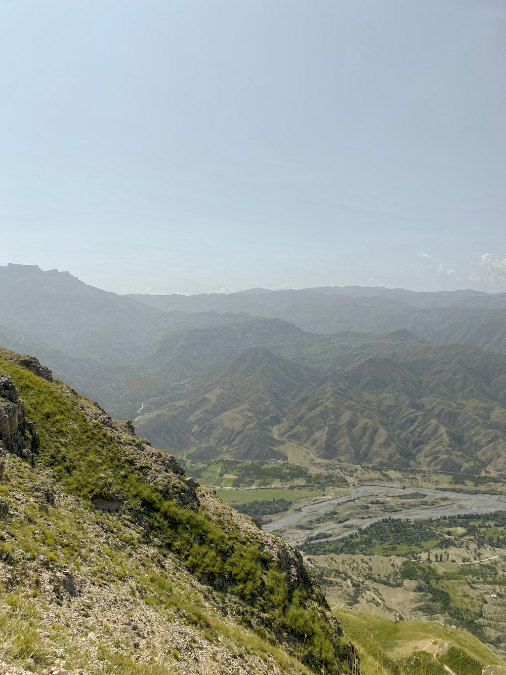 a man sitting on top of a lush green hillside