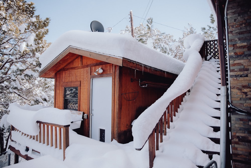 a small wooden building covered in snow