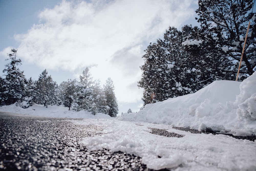 a road that is covered in snow with trees in the background