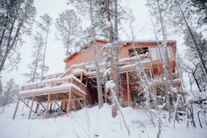 a house in the woods covered in snow